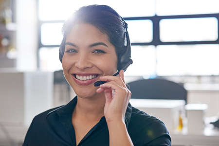 Your answer is a call away. Portrait of a call centre agent at the office.