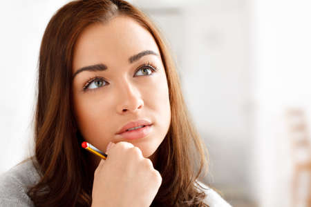 Pretty girl thinking ahead. Shot of a woman daydreaming while at home.