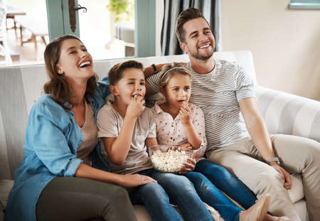 The simplest things in life offer the most pleasure. Shot of a happy young family relaxing on the...