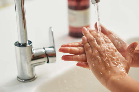 Stay healthy by washing your hands. Cropped shot of an unrecognizable woman washing her hands at a tap.の写真素材