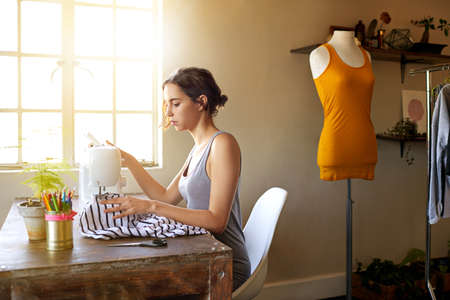 Any day spent sewing is a good day. A young designer making a garment in her workplace.の写真素材