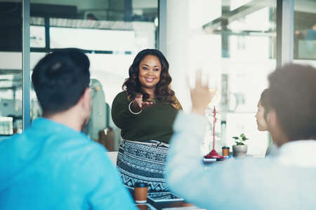 You have a question. Cropped shot of a young businesswoman addressing a colleague during her presentation.の写真素材
