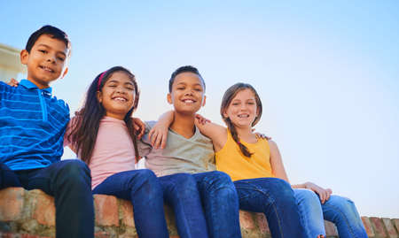 Happiness is having great friends. Shot of a diverse group of children holding each other outside.
