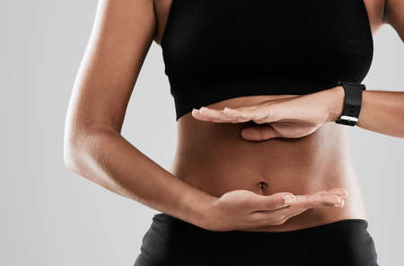 Sticking to a balanced diet. Cropped shot of an unrecognizable woman holding her hands against her...