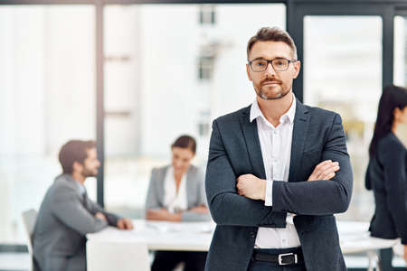Id back my team everyday of the week. Portrait of a businessman in the office with his colleagues in...