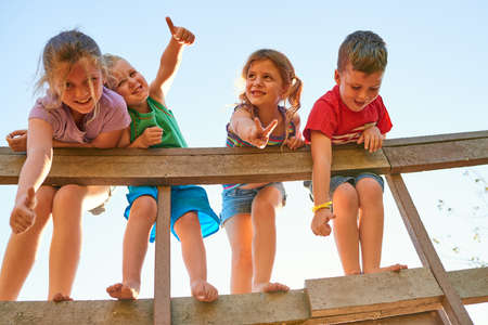 These are their happiest days. Portrait of a group of little children showing thumbs up while playing together outdoors.の写真素材