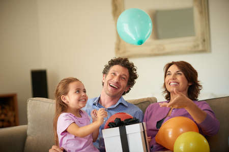 Best birthday ever. Shot of a happy little girl celebrating her birthday with her family.の写真素材