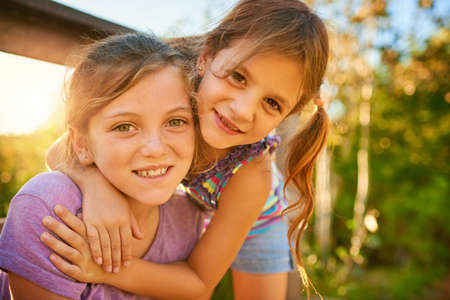 Friends and siblings for life. Portrait of two little girls playing together outdoors.