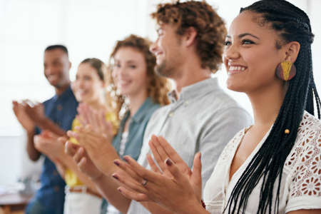 That was a brilliant presentation. Cropped shot of a group of young coworkers applauding with...