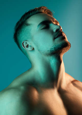 Theres something enticing about his personality. Studio shot of a handsome young man posing against a blue background.の写真素材