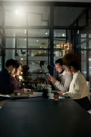Many hands make light work. Shot of a group of young designers working late in the office.