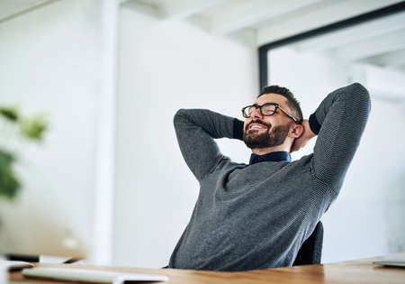 Time to dream about my rewards of hard work. Shot of a young designer taking a break at his office...
