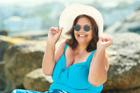 Confidence is wearing that one piece at any age. Shot of an attractive mature woman sitting alone...