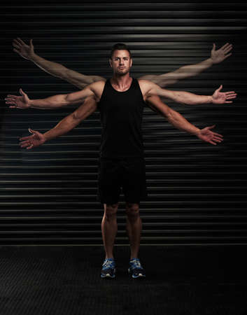 Hes got a full range of motion. Full length portrait of an athletic young man waving his arms in the studio.の写真素材