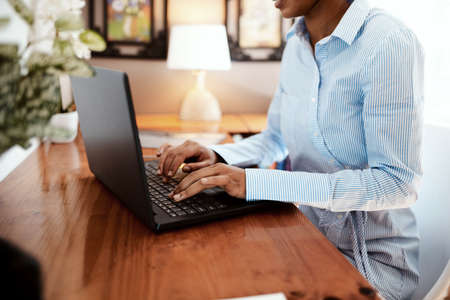 Stay connected to your online professional network. Cropped shot of a businesswoman using a laptop at her desk.の写真素材