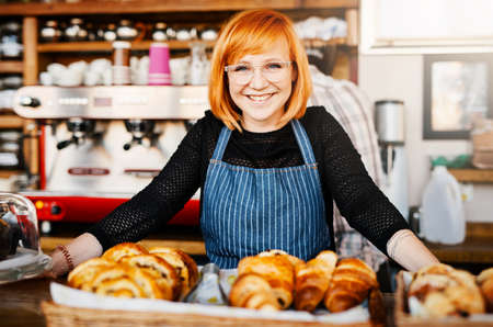 These just came from the oven. Portrait of a confident young woman working in a cafe.の写真素材
