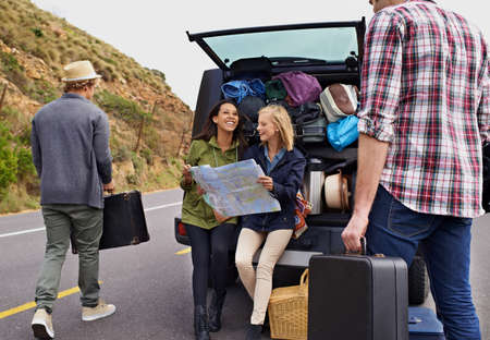 Excited about our road trip. A group of young friends preparing for their camping trip.の写真素材