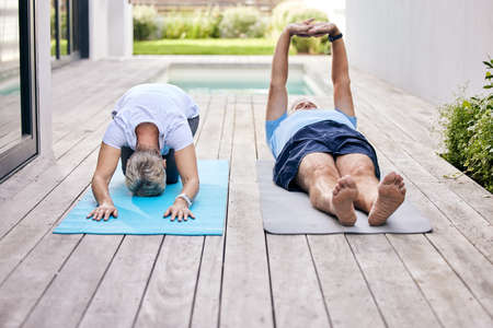 Starting off with some light stretches. Shot of a mature couple exercising together outdoors.の写真素材