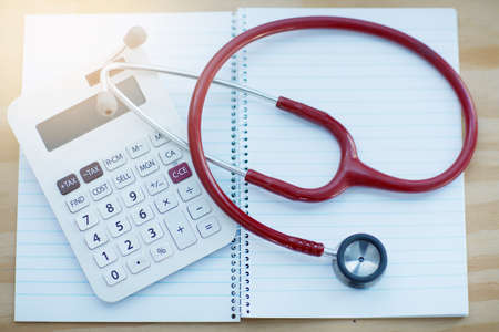 Clinical calculations. Closeup shot of a calculator and stethoscope resting on a notebook on a table.の写真素材