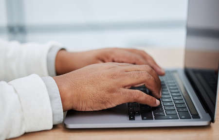 Keeping himself busy with the days tasks. Closeup shot of an unrecognisable businessman using a...