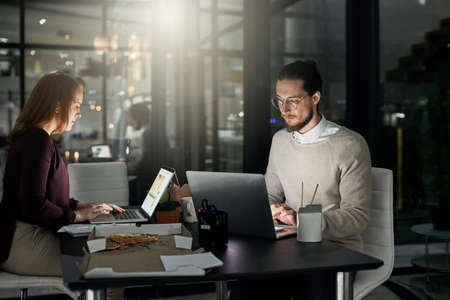 If you can dream it, he can design it. Shot of two young designers working late in the office.の写真素材