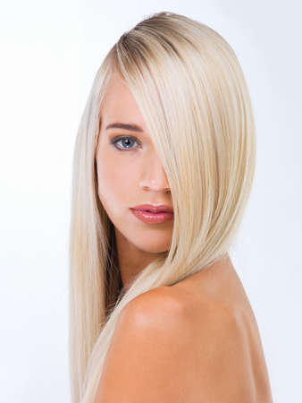 Golden-haired beauty. Studio portrait of a gorgeous young blonde woman against a white background.の写真素材