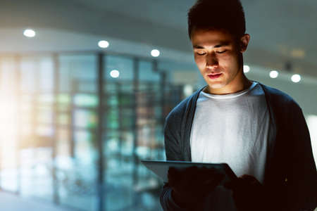 Hes a dedicated programmer. Shot of a handsome young male programmer working late in his office.