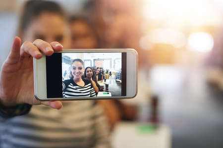 Every study group needs a selfie. Shot of a group of college students posing for a selfie together...