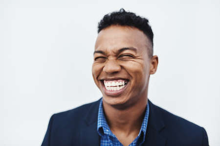 Im the happiest man in the whole world. Studio shot of a young businessman smiling and in good spirits against a grey background.の写真素材