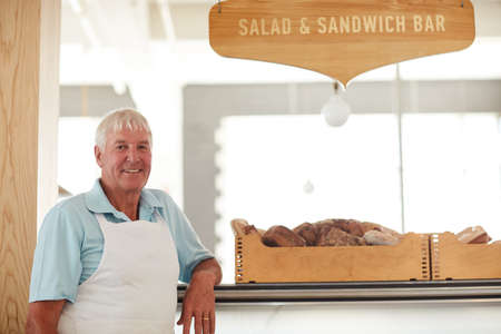 We make the best sandwiches in town. Portrait of a happy senior man working in a bakery.