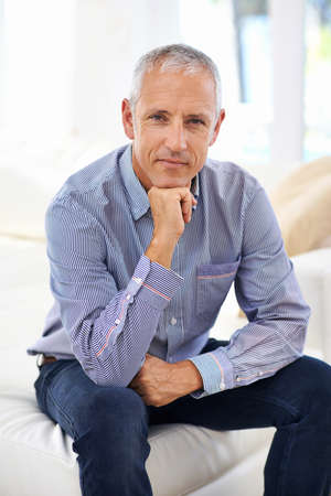 Attitude is everything. Portrait of a thoughtful mature man sitting on a sofa.