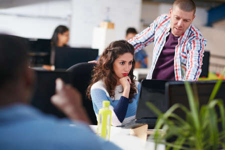 Figuring out the way forward together. Shot of two coworkers using a computer together in a modern...
