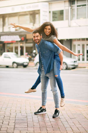 He likes to do anything with me, absolutely anything. Shot of a playful couple out in the city together.の写真素材