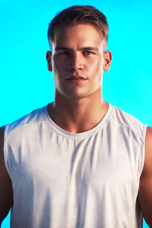 Its all about the will to win. Studio portrait of a handsome young male athlete posing against a blue background.の写真素材
