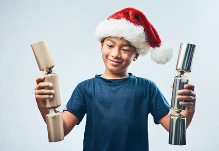 Christmas cracker explosion pending.... Studio shot of a cute little boy wearing a Santa hat and...