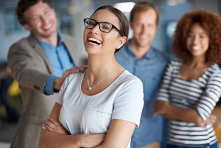 Lifes great with the support of my colleagues. Young businesswoman laughing happily with supportive...