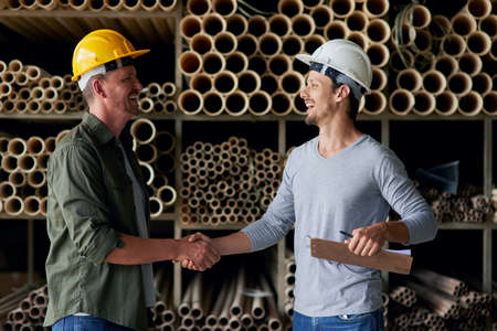 Youve got yourself a deal. Cropped shot of two male construction workers shaking hands while...