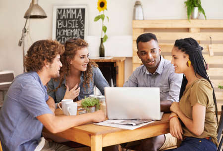 Theyre enjoying each others conversation. A group of friends sitting together in a coffee shop with...