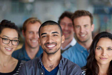 Feeling proud of our achievments. Shot of a smiling group of coworkers standing in an office.の写真素材