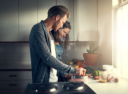 Getting some cooking pointers from mom. Shot of a mother and her adult son cooking together in their...