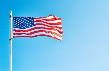 I pledge allegiance to the flag. Low angle shot of the American flag standing on its own outside during the day.の写真素材