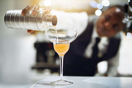 Hes always updating his craft. Cropped shot of a bartender making a cocktail.の写真素材