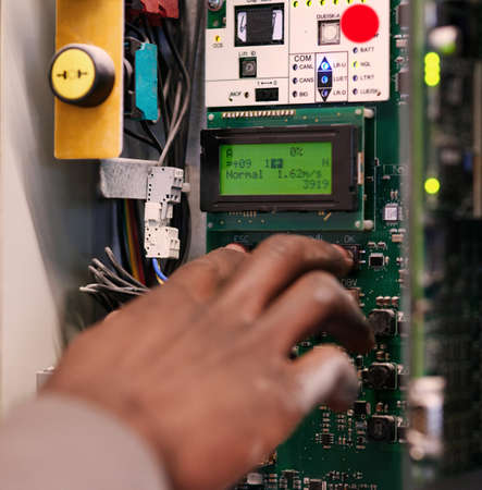 Push to start. Cropped shot of an unidentifiable man pressing a button on an electrical panel.
