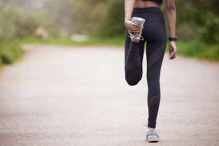 Life is about balance. Rearview shot of an unrecognisable woman stretching her legs while exercising...