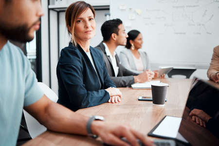 Youre gonna love this meeting. Cropped portrait of an attractive young businesswoman sitting at the boardroom table during a meeting with her colleagues.の写真素材