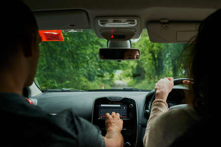 The GPS will get us there. Rearview shot of a young couple sitting in their car ready to depart on...