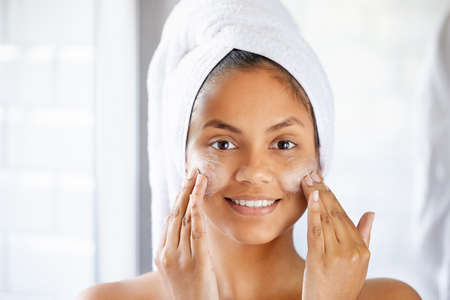 Beauty is not what you see in the mirror. Shot of young woman using with facial moisturiser.