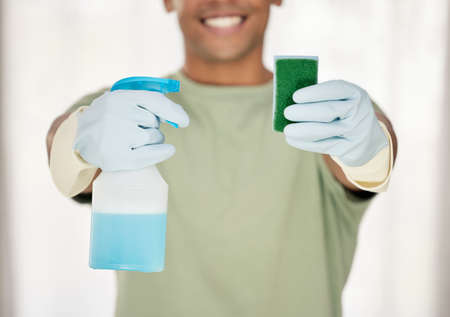 Get your tools at the ready. Shot of a man holding a sponge and a bottle of detergent.の写真素材