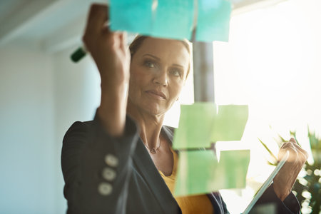 She has a keen eye for strategy. Cropped shot of a mature corporate businesswoman planning on a...