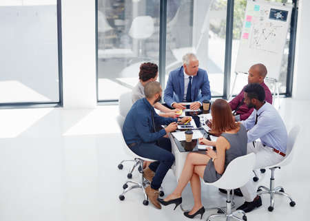 Growing their empire through effective planning. Shot of a group of colleagues having a meeting in the boardroom.の写真素材